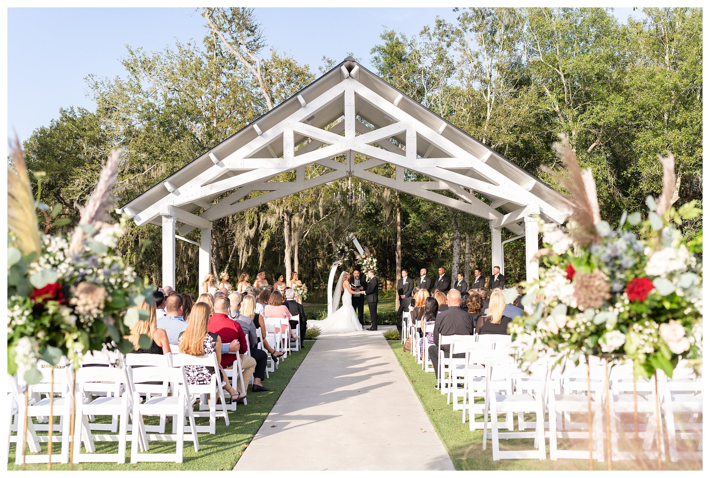 Bride and Groom at the alter during the ceremony while guests watch on in an outdoor ceremony site at the Springs Wallisville in Houston