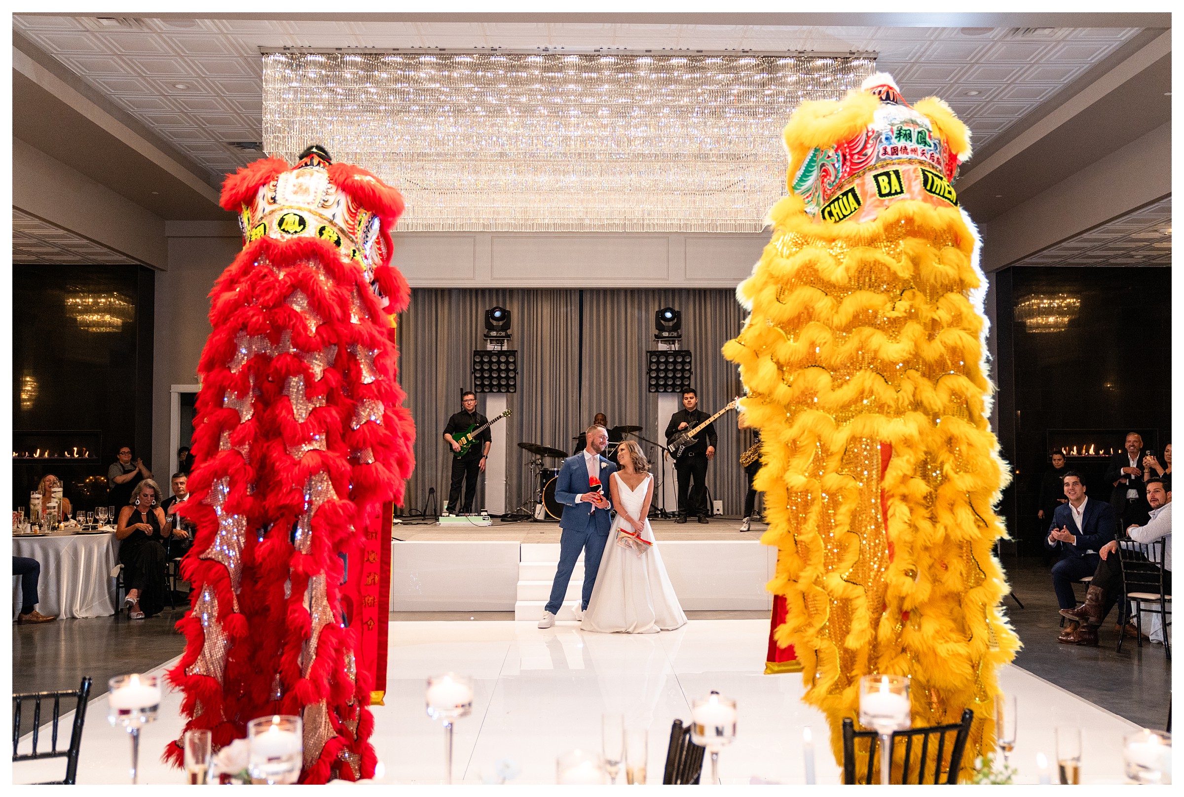 Red and yellow Chinese lions dance for bride in groom in the middle of the dance floor during the wedding reception at Sandlewood Manor in Houston, Texas